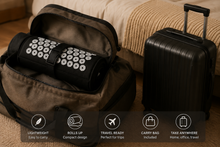 A black cylindrical travel roll-up bag with white circular printed icons, shown inside an open brown duffel bag next to a black hard-shell suitcase on a bed. Text overlays at the bottom highlight features like lightweight, compact design, travel-ready, carry bag included, and take anywhere.