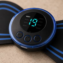A close-up of a circular black electronic control unit with a blue illuminated rim and a digital display showing '19'. The unit has three control buttons labeled with symbols, and it is placed on top of black adhesive pads with blue stripes on a beige textured surface.